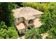 Aerial shot of a home with a unique barrel tile roof surrounded by mature trees for privacy at 1196 Lakeshore Dr, Mount Dora, FL 32757