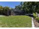 Expansive backyard with a screened pool enclosure, lush green grass, and mature trees at 1196 Lakeshore Dr, Mount Dora, FL 32757