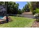 Lush backyard featuring green lawn, perimeter landscaping, and privacy wall with bonus room on the other side at 1196 Lakeshore Dr, Mount Dora, FL 32757