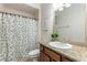 Well-maintained bathroom with a patterned shower curtain, vanity, and warm lighting at 1196 Lakeshore Dr, Mount Dora, FL 32757