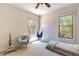 Cozy bedroom with a comfortable chair, hammock swing, and natural light streaming through the windows at 1196 Lakeshore Dr, Mount Dora, FL 32757