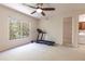 Bedroom with treadmill, natural light, and view to laundry room at 1196 Lakeshore Dr, Mount Dora, FL 32757