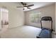 Bright bedroom featuring neutral carpet, a large window, and a treadmill for exercise at 1196 Lakeshore Dr, Mount Dora, FL 32757