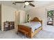 Bright bedroom featuring a wooden bed frame, fan, and neutral carpet at 1196 Lakeshore Dr, Mount Dora, FL 32757