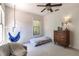 Relaxing bedroom featuring a hanging swing chair, dresser, and sunlit window views at 1196 Lakeshore Dr, Mount Dora, FL 32757
