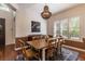 Beautiful dining room boasts large windows, stylish light fixture, and hardwood floors at 1196 Lakeshore Dr, Mount Dora, FL 32757
