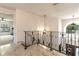 Hallway with decorative railing leading to rooms with natural light at 1196 Lakeshore Dr, Mount Dora, FL 32757