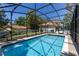 Beautiful screened-in pool with bright blue water and views of the backyard and neighboring house at 1196 Lakeshore Dr, Mount Dora, FL 32757