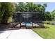 This screened-in pool features a lovely walkway surrounded by mulch and grass at 1196 Lakeshore Dr, Mount Dora, FL 32757