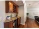 Wet bar features granite countertop, wine rack, mini fridge, with hardwood floors flowing into living room at 1196 Lakeshore Dr, Mount Dora, FL 32757