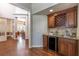 Corner wet bar features granite countertop, wine rack, mini fridge, and view of dining room at 1196 Lakeshore Dr, Mount Dora, FL 32757
