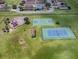 Aerial view showcasing playground and sports facilities, including basketball and tennis courts, in a Gathering-friendly community at 12340 Ne 48Th Loop, Oxford, FL 34484