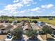 Aerial view of the house with a blue outlined property line, neighborhood, and open fields, showcasing the home's location at 12340 Ne 48Th Loop, Oxford, FL 34484