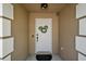 Close-up of the front door with decorative wreath, sidelights, and modern hardware in a welcoming entryway at 12340 Ne 48Th Loop, Oxford, FL 34484