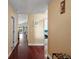 Inviting hallway featuring gleaming hardwood floors, neutral paint and an open view into the living spaces at 12340 Ne 48Th Loop, Oxford, FL 34484
