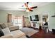 Cozy living room with sliding glass doors to the patio, a large TV, and hardwood floors at 12340 Ne 48Th Loop, Oxford, FL 34484