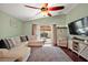 Bright living room with hardwood floors, comfortable seating, and sliding glass doors leading to the outdoor patio at 12340 Ne 48Th Loop, Oxford, FL 34484