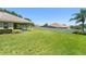 Expansive backyard showcasing lush green lawn and a covered patio of the home at 13045 Colonnade Cir, Clermont, FL 34711
