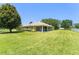 Expansive backyard showcasing lush green lawn and a covered patio of the home at 13045 Colonnade Cir, Clermont, FL 34711