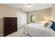 Calm bedroom features carpet, a dark dresser, closet, and a bright window creating a cozy ambiance at 13045 Colonnade Cir, Clermont, FL 34711