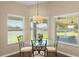Sunlit breakfast nook featuring a glass table, ornamental chairs, and large windows overlooking the backyard at 13045 Colonnade Cir, Clermont, FL 34711