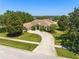 Aerial view of single-story home with well-manicured lawn and circular driveway at 13045 Colonnade Cir, Clermont, FL 34711