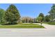 Attractive one-story home with mature trees, a well-kept lawn, and a circular driveway at 13045 Colonnade Cir, Clermont, FL 34711