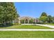 Charming single-story home featuring a well-manicured lawn and mature trees at 13045 Colonnade Cir, Clermont, FL 34711