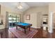 Spacious game room featuring a pool table, wood floors, ceiling fan, and access to an outdoor patio at 13045 Colonnade Cir, Clermont, FL 34711