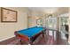 Bright game room featuring a pool table, wood floors, a decorative rug, and a glimpse of the front door at 13045 Colonnade Cir, Clermont, FL 34711