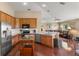 Open kitchen with wood cabinets, stainless steel appliances, modern countertops, and a clear view of the living room at 13045 Colonnade Cir, Clermont, FL 34711
