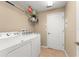 Bright laundry room with a washer, dryer, shelving, and storage space to make laundry easier at 13045 Colonnade Cir, Clermont, FL 34711