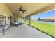 Covered patio featuring a wicker sofa set, ceiling fans, and a view of the spacious backyard at 13045 Colonnade Cir, Clermont, FL 34711