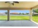Covered patio featuring a wicker sofa set, ceiling fans, and a view of the spacious backyard at 13045 Colonnade Cir, Clermont, FL 34711