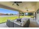 Covered patio featuring a wicker sofa set, ceiling fans, and a view of the spacious backyard at 13045 Colonnade Cir, Clermont, FL 34711