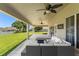 Covered patio featuring a wicker sofa set, ceiling fans, and a view of the spacious backyard at 13045 Colonnade Cir, Clermont, FL 34711