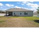 Rear view of the home showcasing a screened patio and spacious backyard at 13328 Lake Yale View Loop, Grand Island, FL 32735