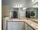 Bright bathroom featuring a double sink vanity, large mirrors, neutral walls, and a tiled walk-in shower at 13328 Lake Yale View Loop, Grand Island, FL 32735