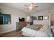 Spacious bedroom showcasing a wood dresser, wood floors, a ceiling fan, and ensuite bathroom entrance at 13328 Lake Yale View Loop, Grand Island, FL 32735