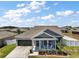 Charming single-story home featuring a covered front porch, attached garage, and well-maintained landscaping at 13328 Lake Yale View Loop, Grand Island, FL 32735