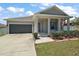 Inviting single-story home showcasing a covered front porch, attached garage, and manicured lawn at 13328 Lake Yale View Loop, Grand Island, FL 32735