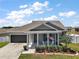 Charming single-story home with a well-manicured lawn, cozy porch, and two-car garage at 13328 Lake Yale View Loop, Grand Island, FL 32735