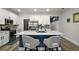 Bright eat-in kitchen boasts a marble island, stainless steel appliances, white cabinetry and wood flooring at 13328 Lake Yale View Loop, Grand Island, FL 32735