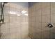 Tiled shower featuring tiled walls, a glass door, a shower head, and a built-in shelf for toiletries at 13328 Lake Yale View Loop, Grand Island, FL 32735