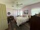 Bright bedroom with a floral comforter and wood-look floors and ceiling fan at 1616 Lauren Ln, Lady Lake, FL 32159