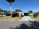 Charming single-story home featuring a well-kept lawn and a shaded carport on a sunny day at 1616 Lauren Ln, Lady Lake, FL 32159