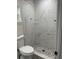 Modern bathroom featuring a beautiful glass enclosed shower with stylish marble-look tile and stone flooring at 16487 Sw 55Th, Ocala, FL 34473