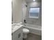 Bathroom featuring marble-look tile, a window, shower with a tub, and vanity with modern black hardware at 16487 Sw 55Th, Ocala, FL 34473