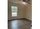 Bright bedroom with a ceiling fan, wood-look flooring, and a window providing natural light and outdoor views at 16487 Sw 55Th, Ocala, FL 34473