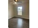 Bright bedroom with a ceiling fan, wood-look flooring, and a window for ample natural light and outdoor views at 16487 Sw 55Th, Ocala, FL 34473